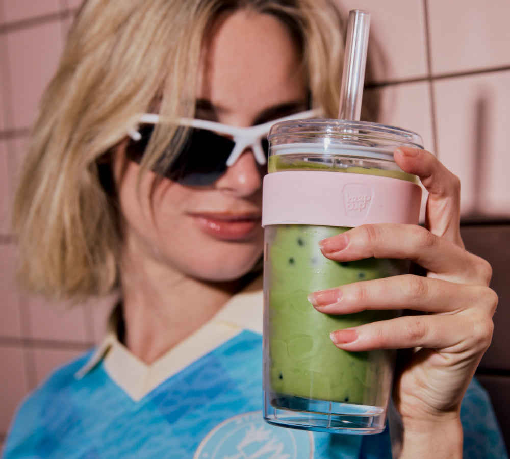 Girl in sunnies holding up pink Cold Cup Longplay filled with iced match