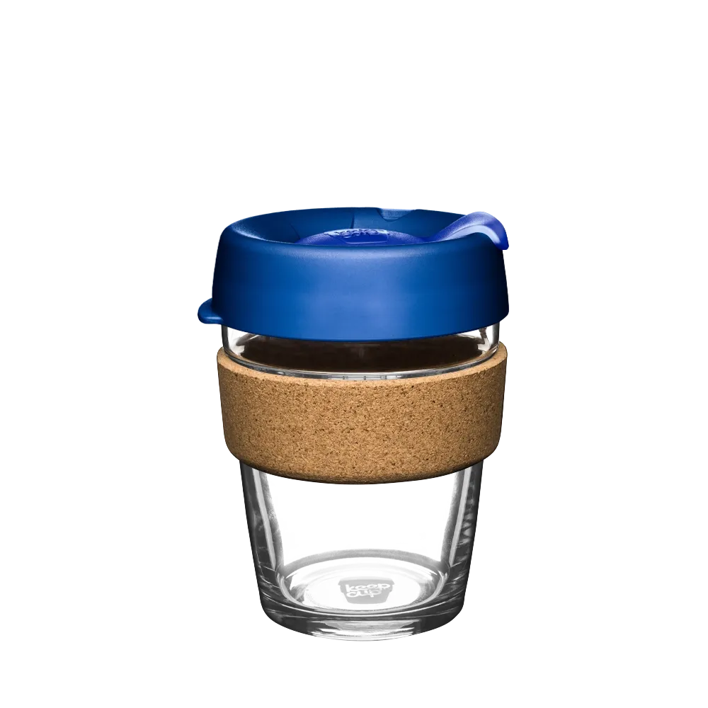 KeepCup Brew Cork M 12oz in Electric Blue, featuring a clear glass cup with cork band and deep blue silicone lid with sip-through opening, shown against a white background.