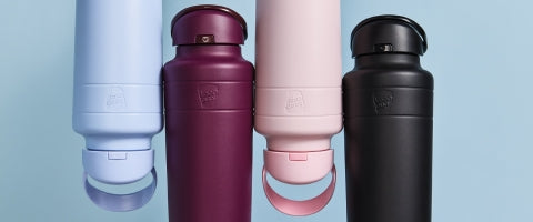 Four water bottles in different colors on a light blue background