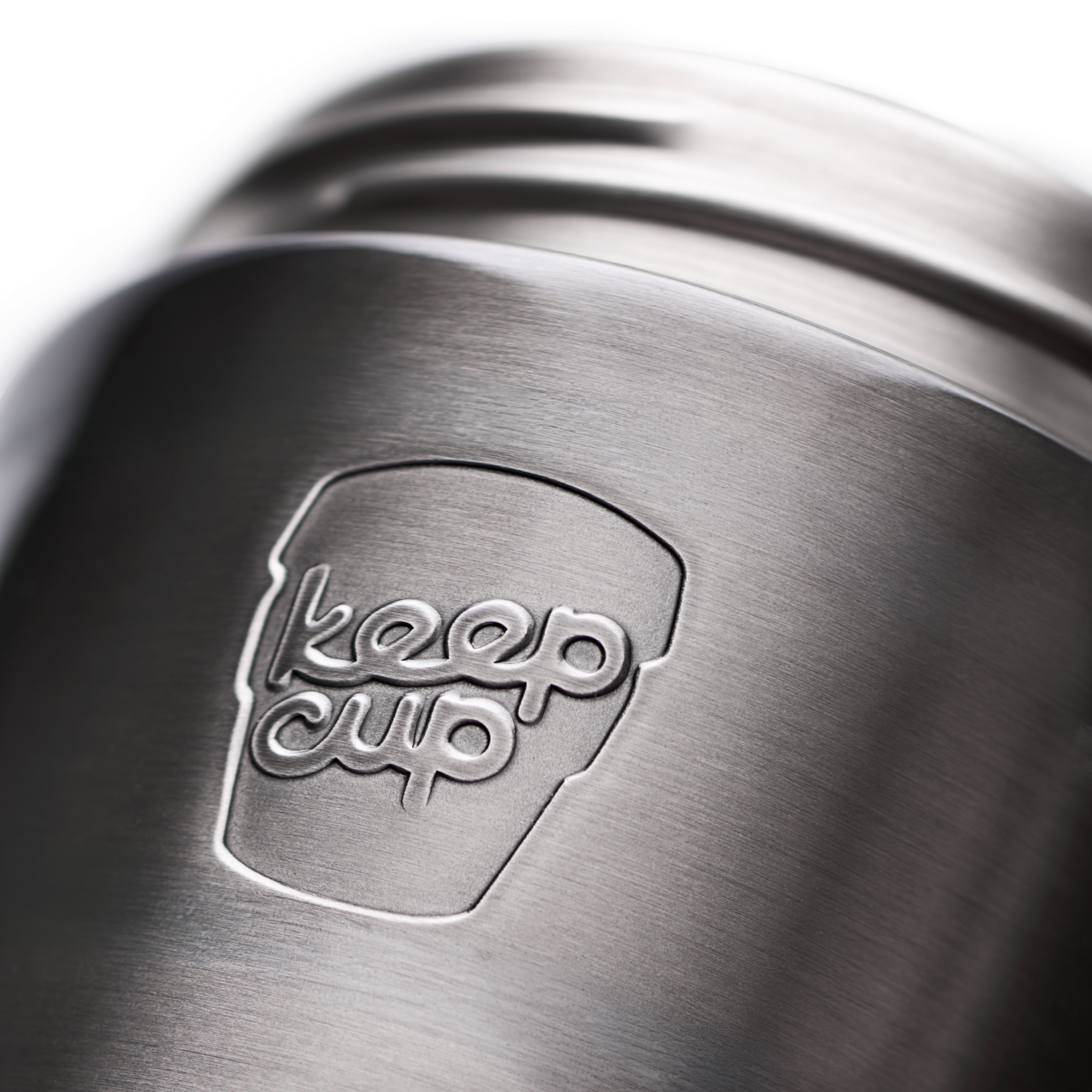 Close-up of a brushed stainless steel KeepCup travel mug with the 'keep cup' logo embossed on the side, set against a bright white background.