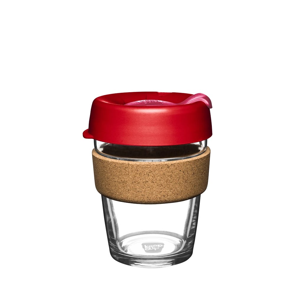 KeepCup Brew Cork M 12oz in Daybreak, featuring a clear tempered glass cup with natural cork band and red lid with sipper opening, shown from a straight-on angle against a white background.