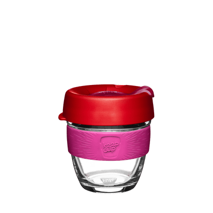 KeepCup reusable coffee cup with clear glass base, pink silicone grip band and red lid with drinking spout