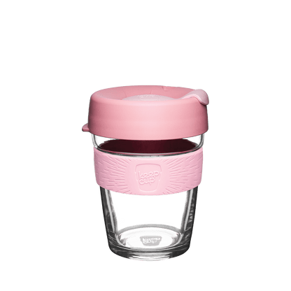 KeepCup glass reusable coffee cup with pink silicone sleeve and lid on a white background