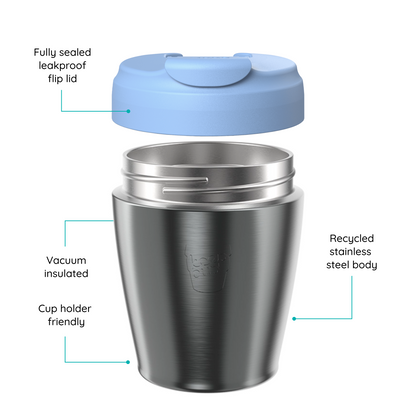 Stainless steel KeepCup travel tumbler with a light blue flip lid shown floating above the cup, with callout lines and text describing features like a sealed leakproof flip lid, vacuum insulation, recycled stainless steel body, and cup holder friendliness on a white background.