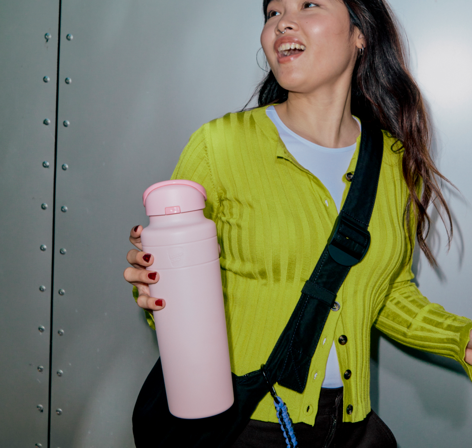 Person holding an Ora water bottle in Pashmak Pink with a plain background