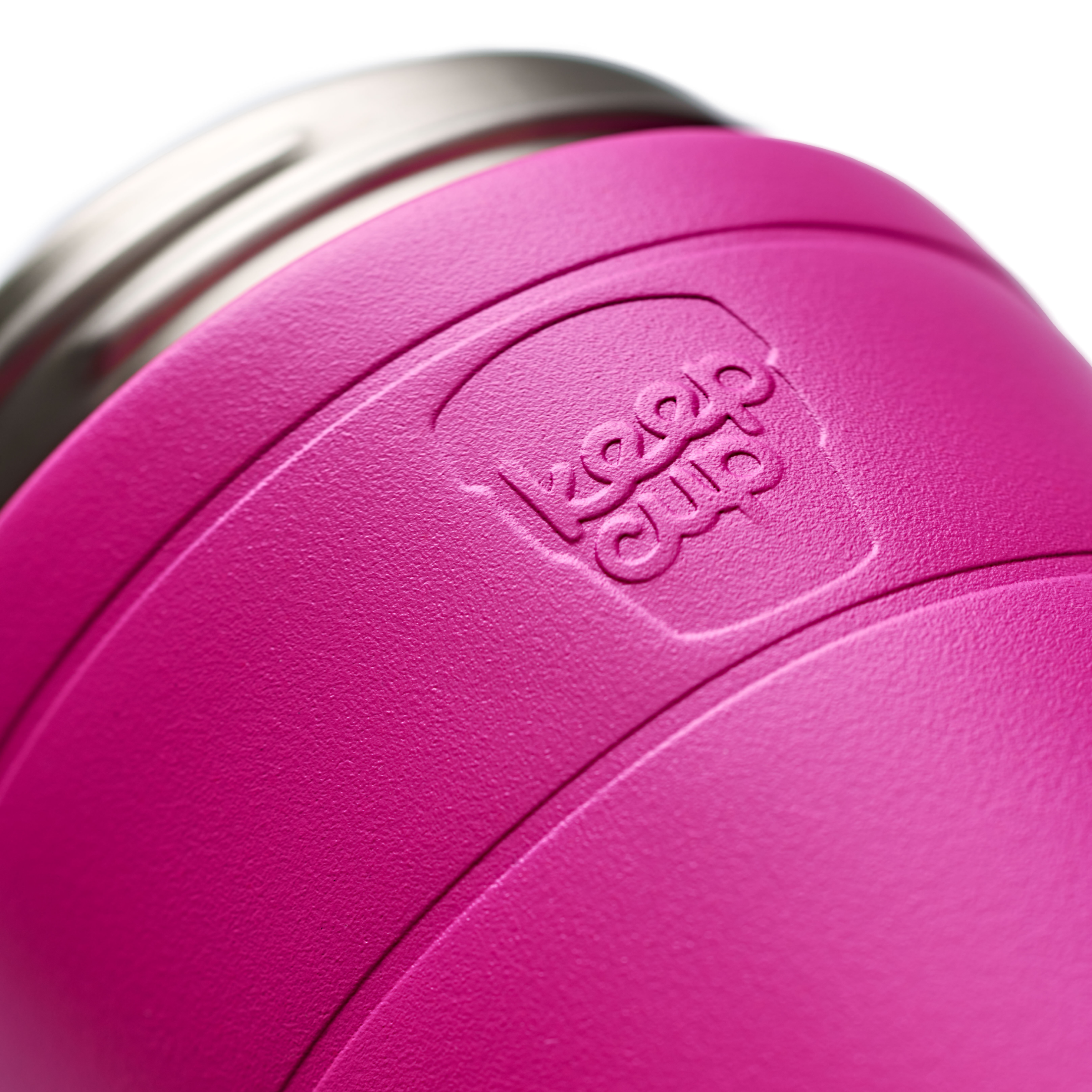 Close-up of a bright pink vacuum-insulated KeepCup tumbler with a stainless steel rim and an embossed  brand logo on the side.