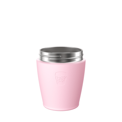 KeepCup Helix Stainless Steel Cup Base in soft pink, shown from a front angle against a white background, featuring the embossed KeepCup logo and silver stainless steel rim.