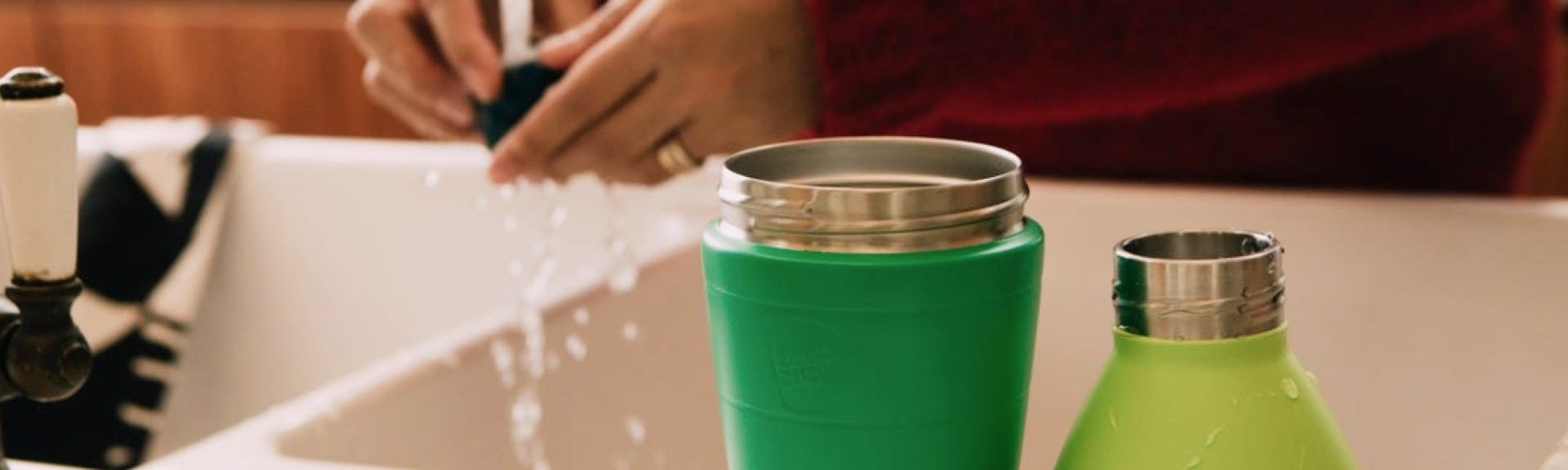 Woman holding KeepCup Traveller in Nitro and woman holding KeepCup Cold Cup Longplay with iced 
