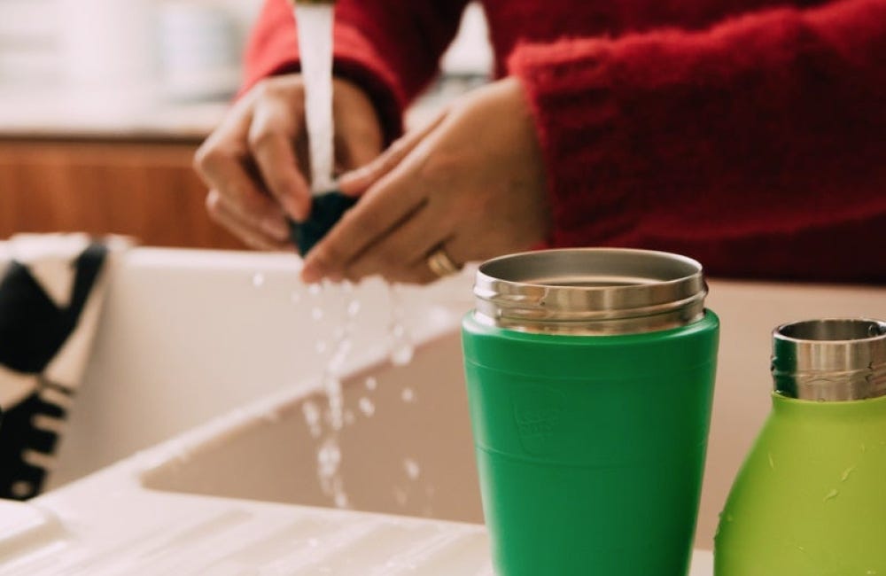 Woman holding KeepCup Traveller in Nitro and woman holding KeepCup Cold Cup Longplay with iced 