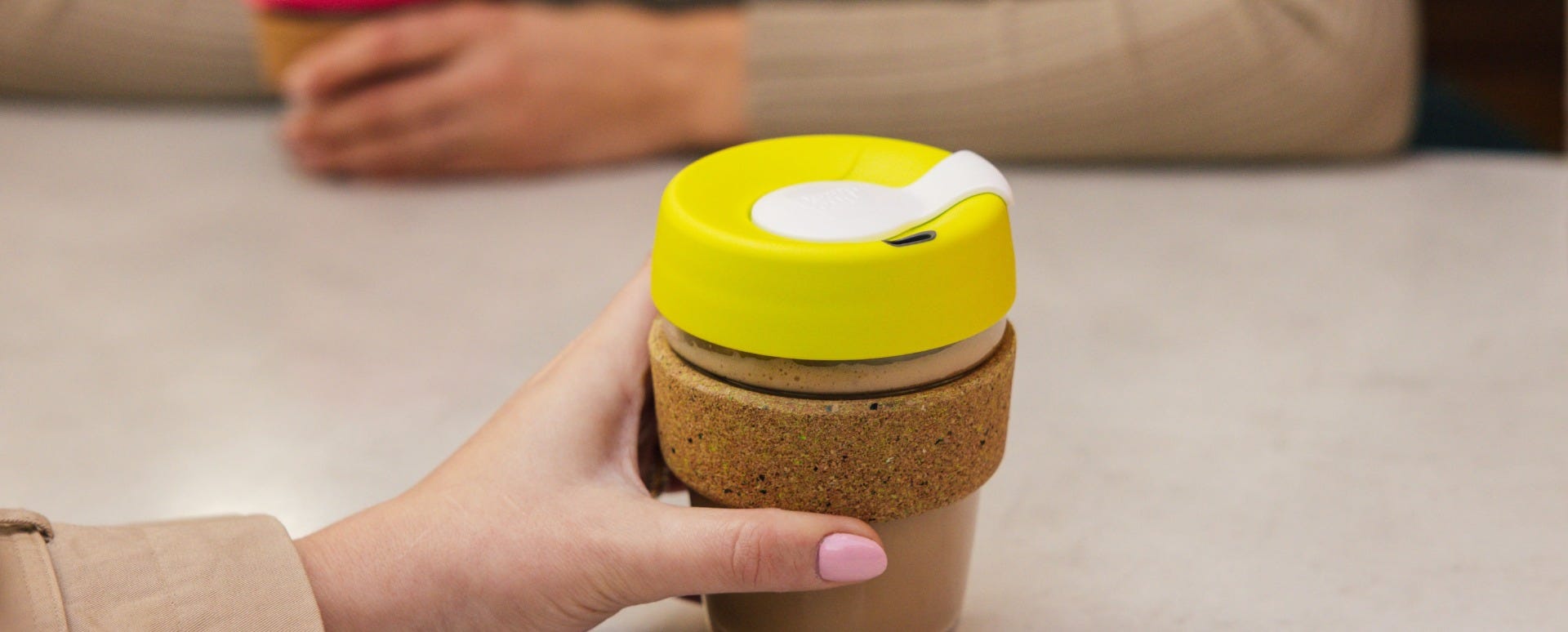 Woman holding KeepCup Brew Cork Ace 16oz with coffee