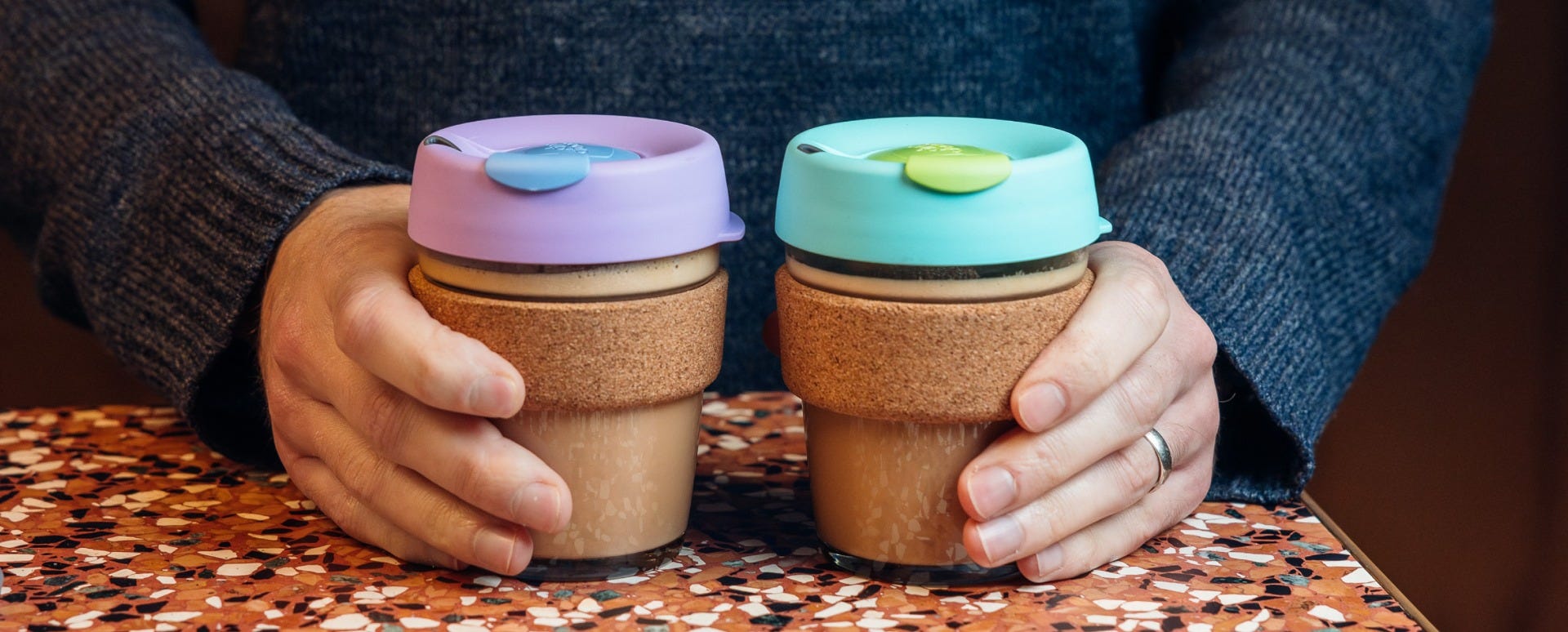 Woman holding two KeepCup Brew Corks 12oz with coffee