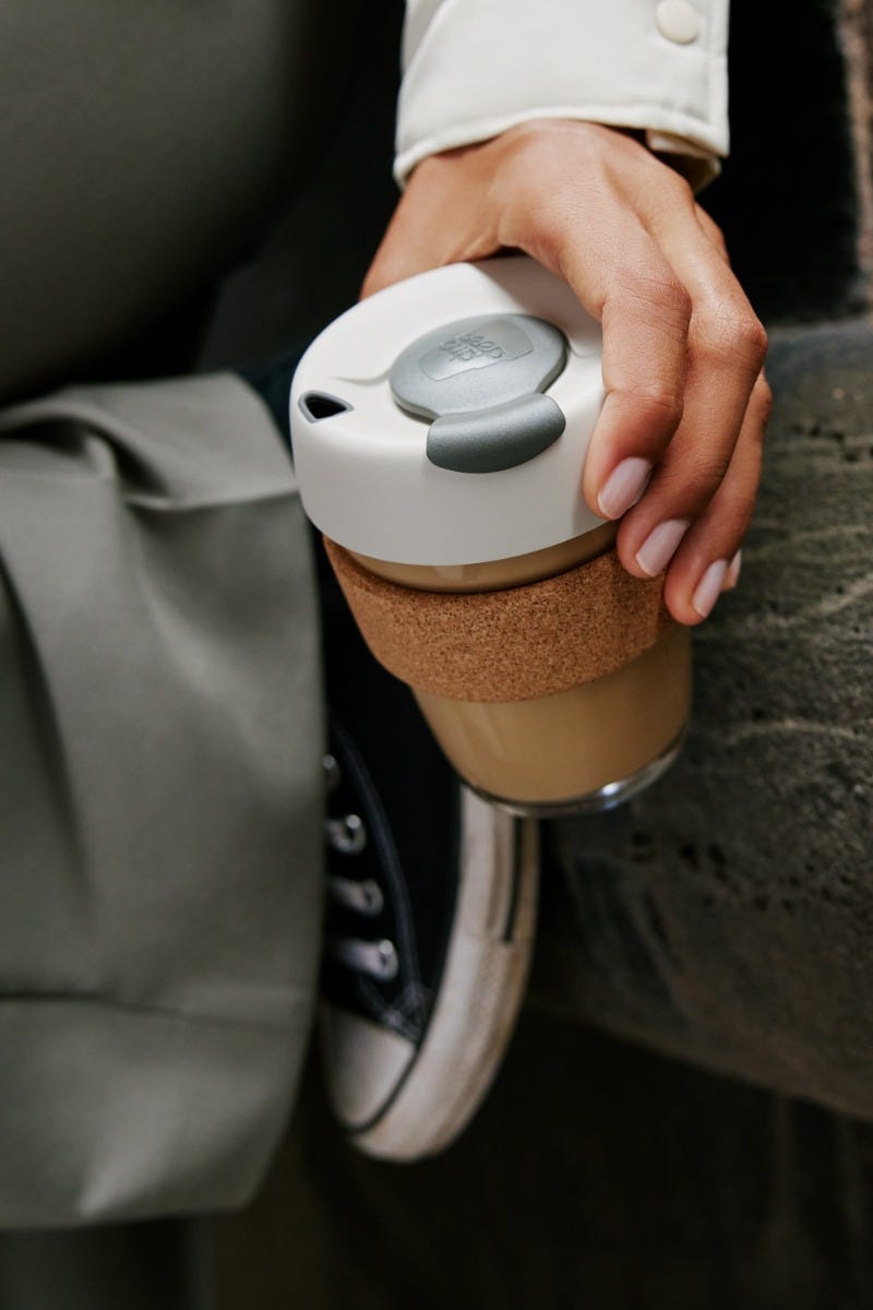 Woman holding two KeepCup Brew Corks 12oz with coffee