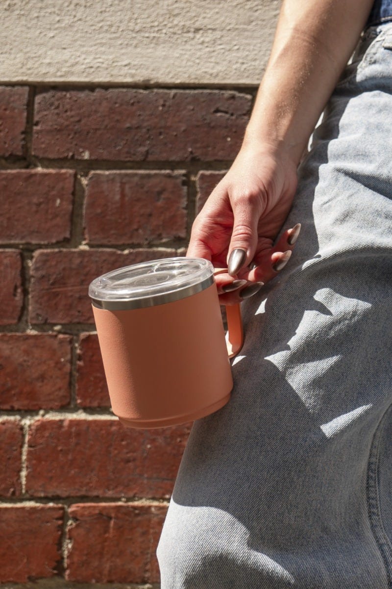 Woman holding KeepCup Camp Mug 12oz with coffee
