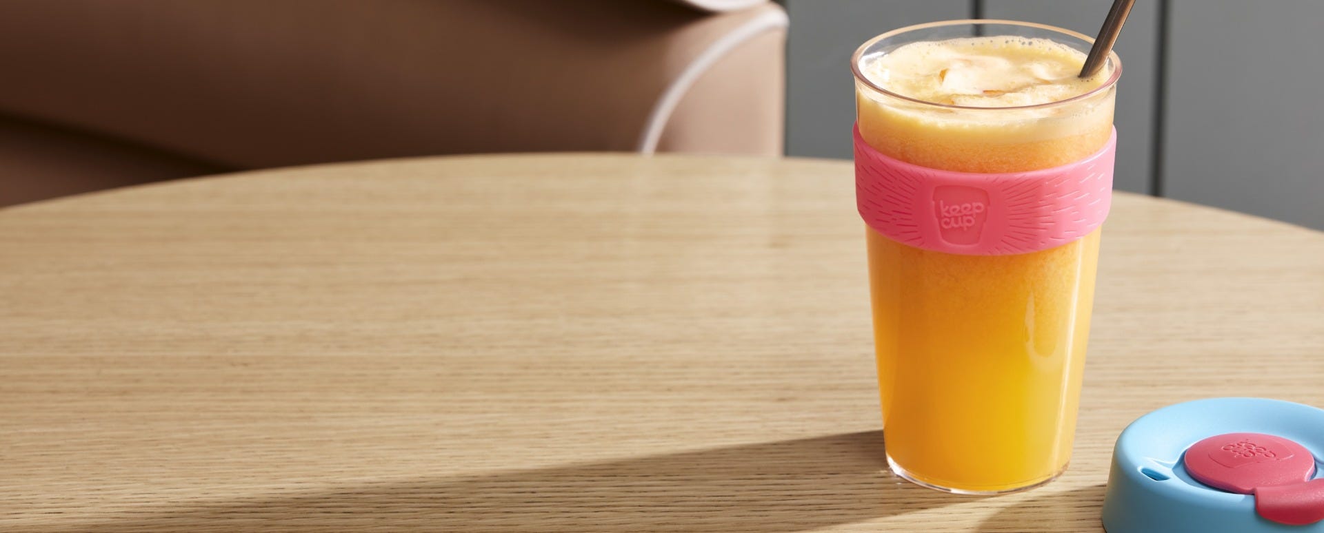 KeepCup Original Clear L 16oz sitting on table with juice