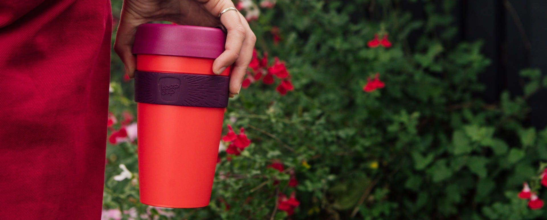 Woman holding KeepCup Original Large 16oz cup in the garden