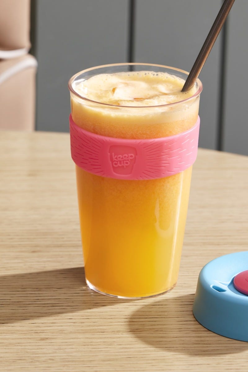 Woman holding KeepCup Sip & Chill Original Clear reusable cup with iced coffee and iced tea